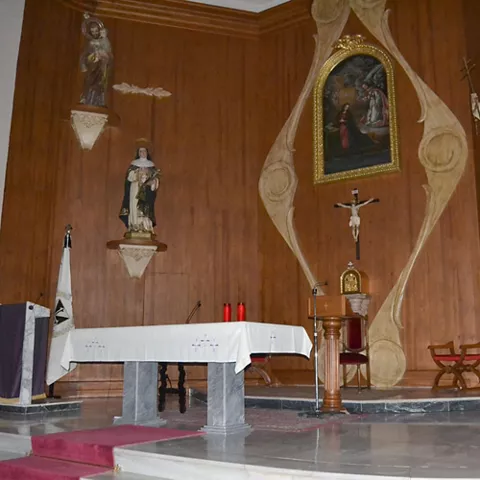 Detalle del altar con imágenes religiosas y retablo sencillo.