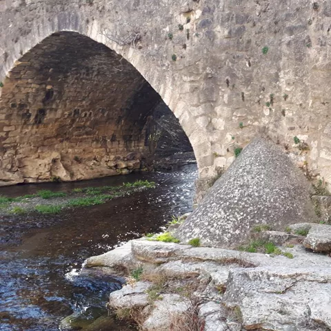 Arcos de piedra junto a la orilla del río.