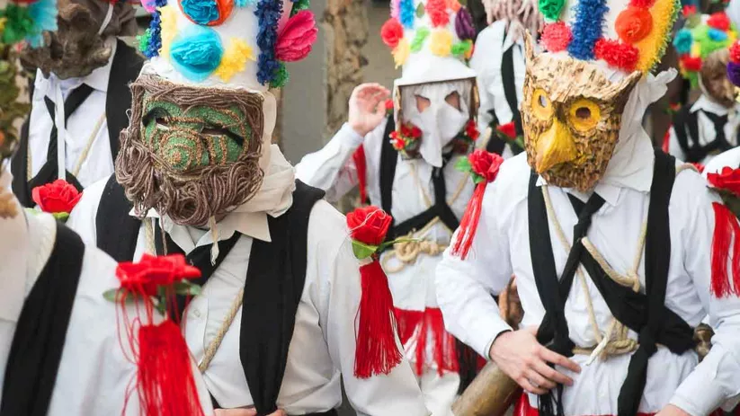 Desfile festivo con máscaras tradicionales.