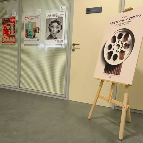 Cartel de festival cultural colocado sobre un caballete.