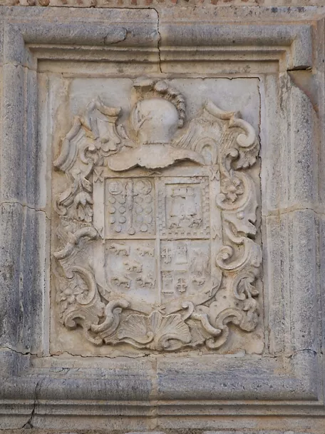 Escudo heráldico tallado en piedra en fachada histórica
