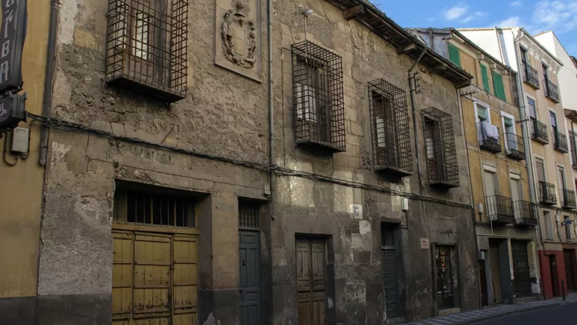 Fachada antigua con balcones y rejas en calle estrecha