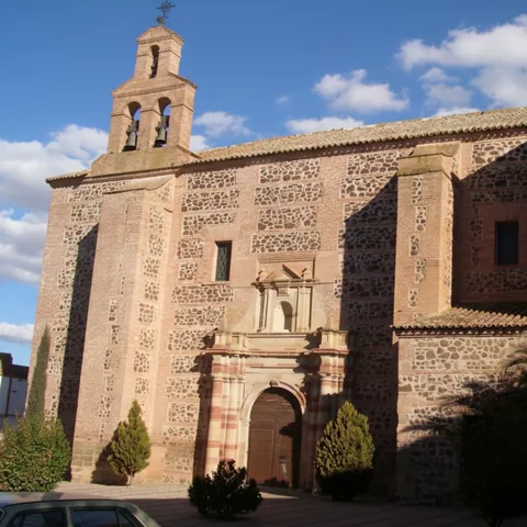 Iglesia parroquial de Castellar de Santiago con portada barroca y campanario de ladrillo y mampostería.