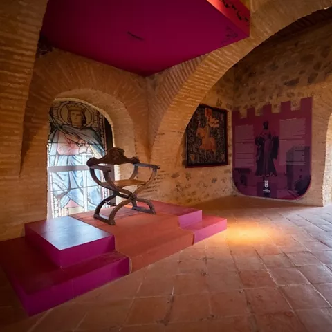 Sala interior de fortaleza con arcos y paneles expositivos