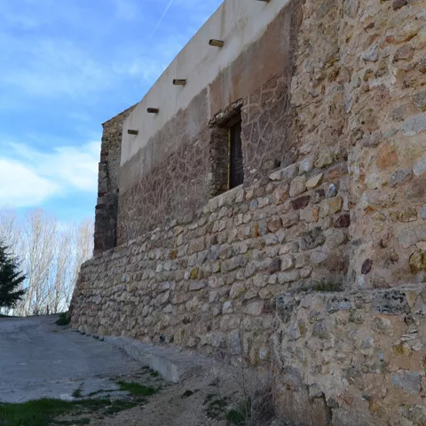 Muralla de piedra junto a camino rural.
