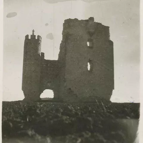 Fotografía antigua de torre y muros en ruinas