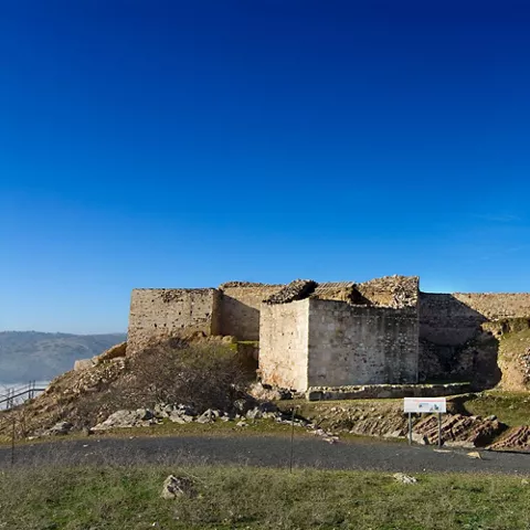 Estructura defensiva de piedra con restos de torres y muros escalonados