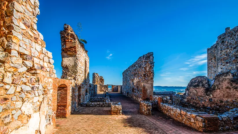 Ruinas de castillo medieval con murallas de piedra.