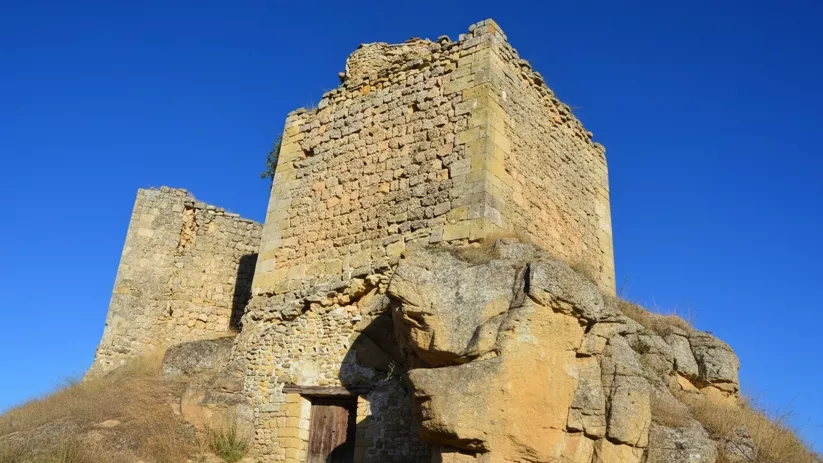Estructura defensiva semiderruida en paisaje abierto.