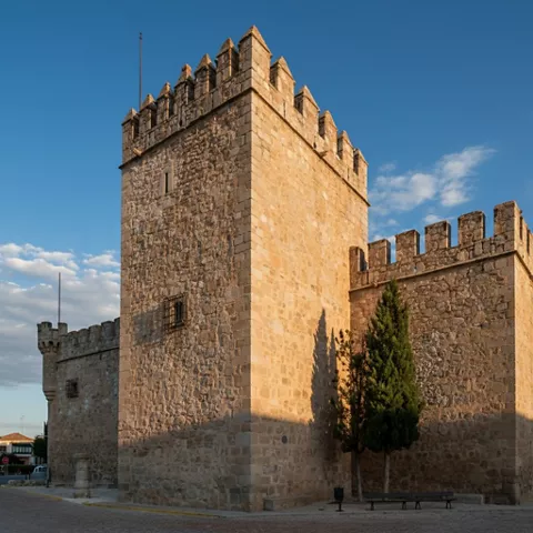 Torre almenada de castillo iluminada por el sol