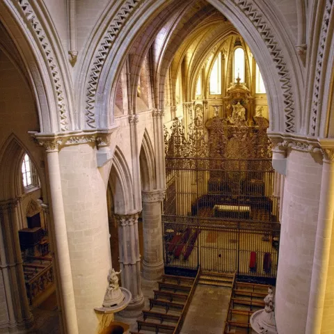 Interior catedralicio con bóvedas y altar dorado