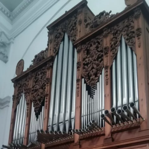 Órgano completo en el interior de un templo con consola iluminada.
