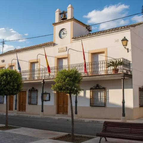 Edificio municipal con balcón y banderas