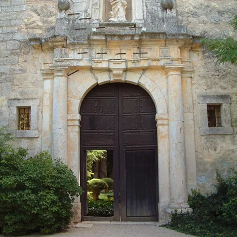 Portada de piedra con arco y escultura.