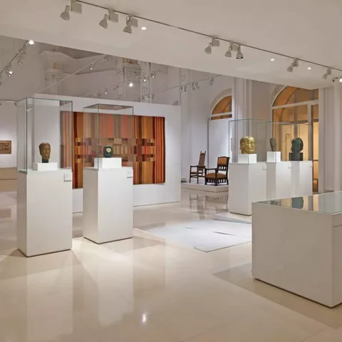 Sala expositiva con esculturas en urnas de cristal.