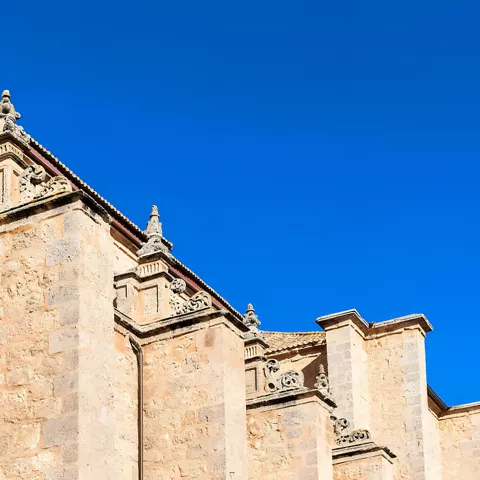 Detalle de contrafuertes y cornisas de piedra bajo cielo despejado