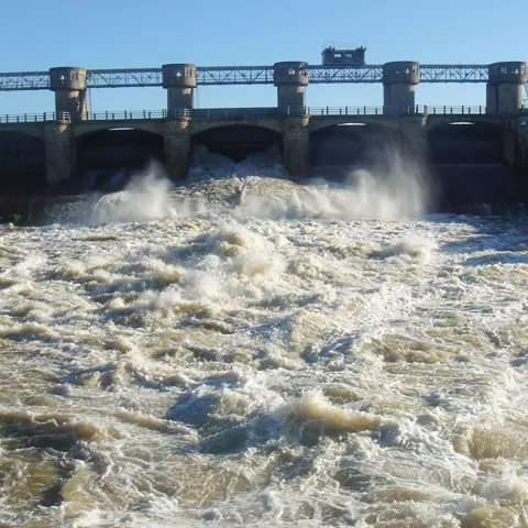 Compuertas de presa con fuerte caudal de agua en descenso