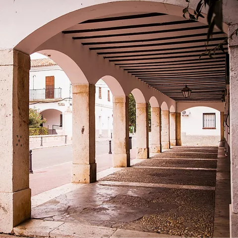 Soportales con columnas de piedra en una plaza urbana