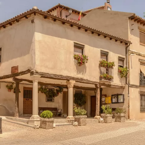 Casa tradicional con soportales y balcones con flores.