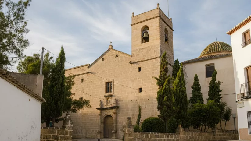 Iglesia de piedra con portada sencilla y cúpula cubierta de tejas.