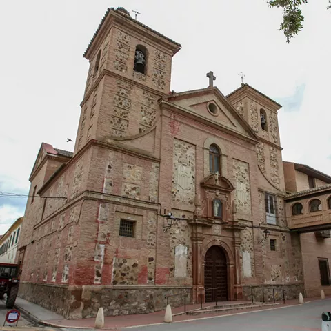 Fachada de iglesia de piedra con dos torres y portada central.