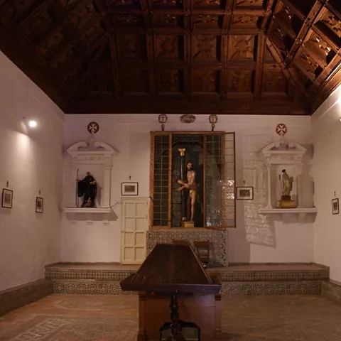 Capilla con esculturas en hornacinas y techo de madera decorado.