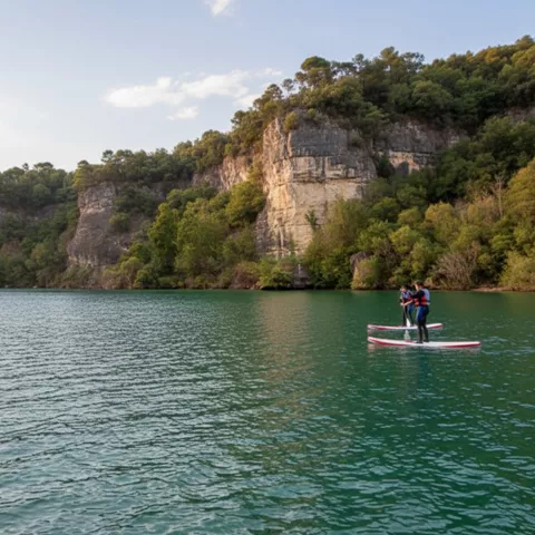 Personas en paddle surf frente a paredes rocosas
