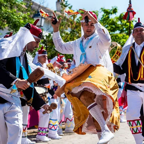 Baile tradicional al aire libre con castañuelas y vestimenta típica.