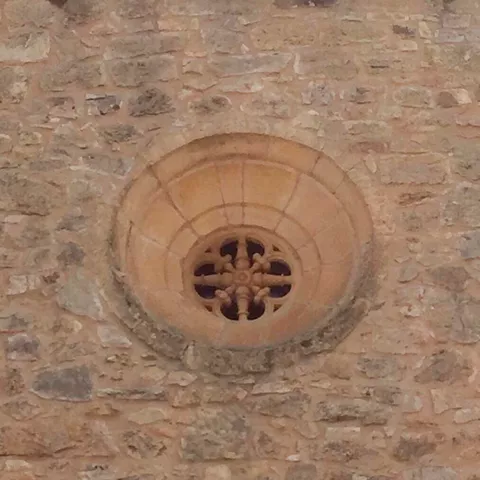 Ventana circular en pared de piedra.