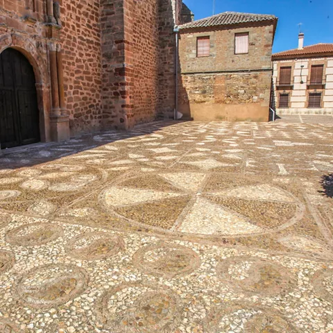Suelo empedrado con dibujos geométricos junto a la iglesia.