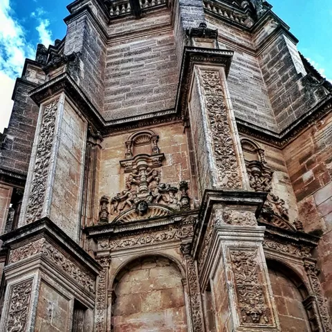 Torre monumental con decoración escultórica en altura.