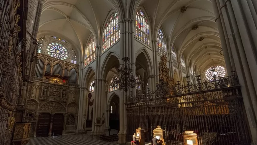 Intérpretes tocando órganos portátiles frente a vitrales y rejas ornamentales.