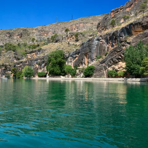 Lago rodeado de acantilados y vegetación