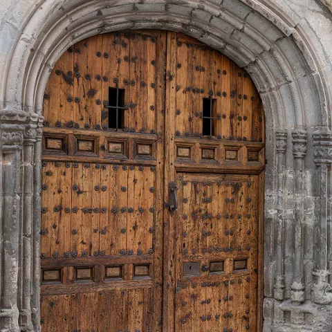 Puerta de madera en arco de piedra medieval