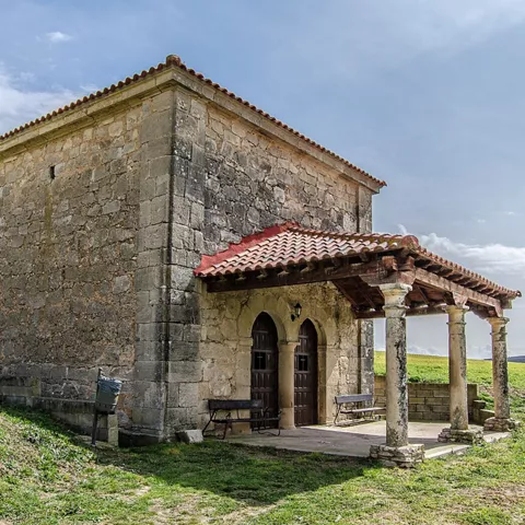 Pequeña ermita de piedra en un entorno abierto y natural.