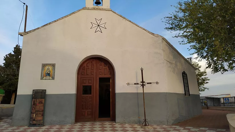 Pequeña ermita blanca con campanario y cruz