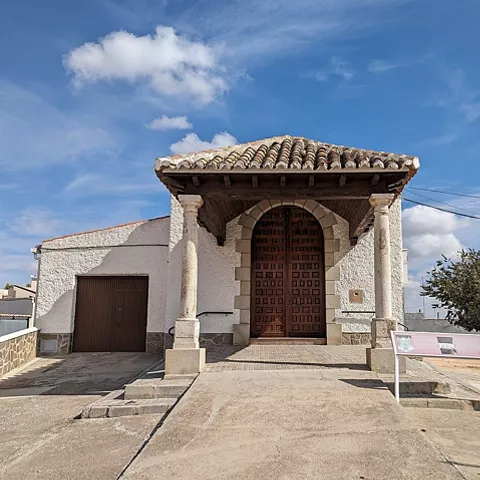 Ermita sencilla con pórtico y puerta de madera.