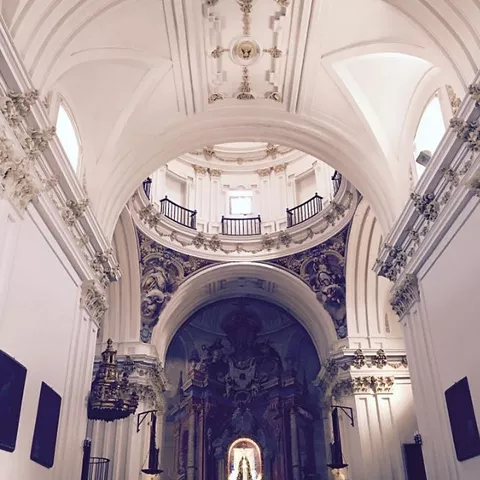 Nave de iglesia con bóveda alta y altar al fondo.
