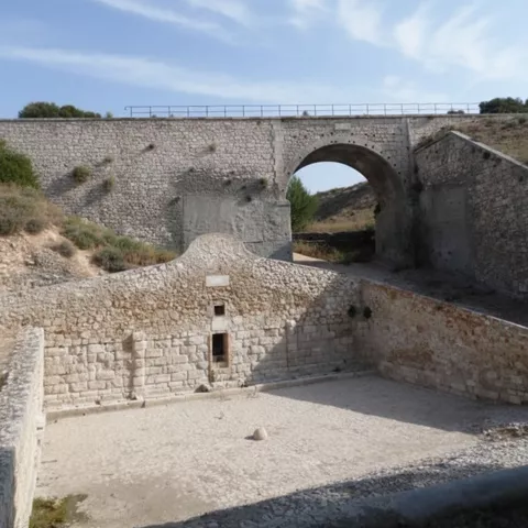 Antiguo puente de piedra sobre cauce canalizado