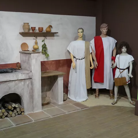 Recreación de cocina antigua con figuras vestidas con túnicas