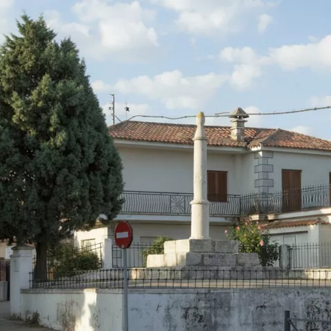 Pilar de piedra tradicional en entorno residencial tranquilo.