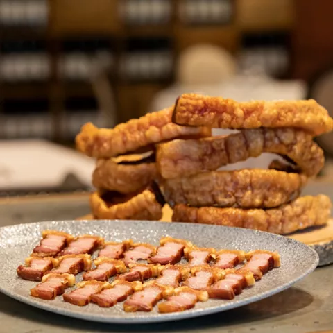 Plato de torreznos crujientes y panceta en láminas