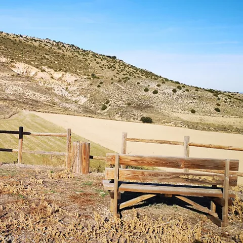 Área de descanso con banco y panel informativo