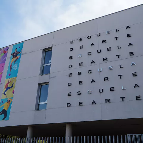 Fachada moderna de edificio cultural con carteles artísticos.