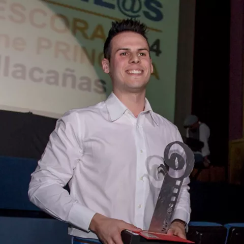 Hombre sosteniendo un trofeo en un escenario