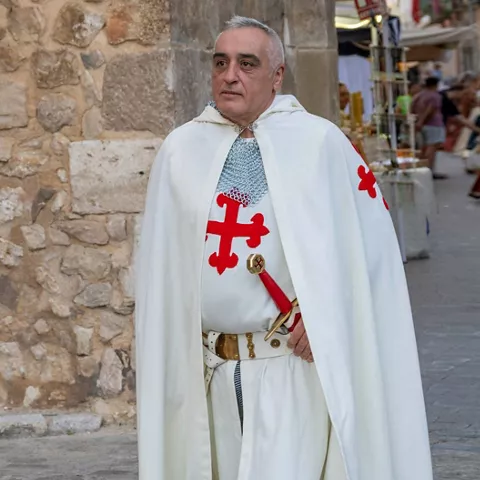 Caballero con capa en fiesta histórica.