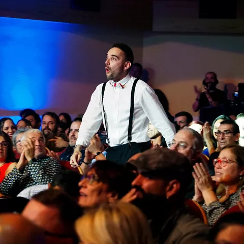 Hombre de pie entre el público durante una gala