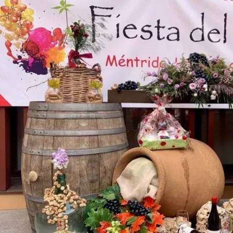 Decoración festiva con barricas, uvas, flores y elementos relacionados con el vino.