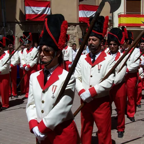 Participantes con uniformes históricos en desfile.