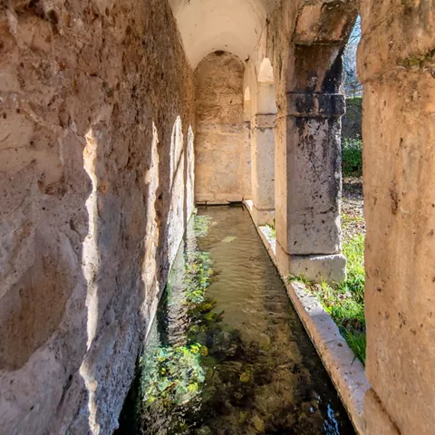 Canal de agua cubierto con muros de piedra.